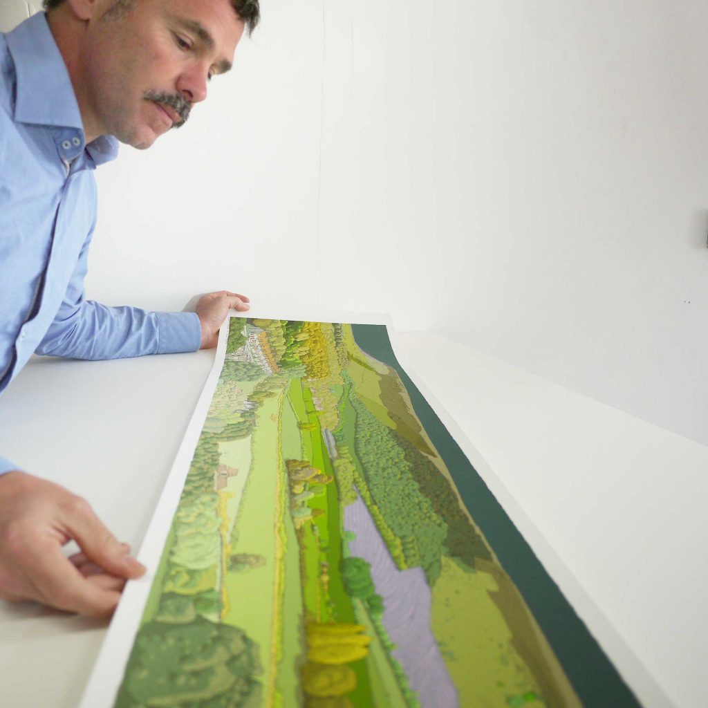 artist alej ez inspecting in his studio his panoramic art print titled Firle from Glynde